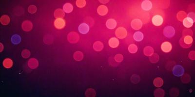 The primary subject of the image is a pink background with a pattern of red and white lights. The setting appears to be a dark room, and the visual style is a close-up of the pink background with the lights. The colors and mood of the image are predominantly pink and red, creating a warm and inviting atmosphere.