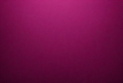 The primary subject of the image is a close-up of a pink surface. The setting is a dark background, which contrasts with the pink surface. The visual style is a photo, capturing the details of the pink surface. The colors and mood of the image are predominantly pink, creating a warm and inviting atmosphere.