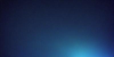 The primary subject of the image is the night sky, which is filled with stars. The setting is a dark, cloudy night, with the sky being the main focus of the image. The visual style is a photo, capturing the beauty of the night sky. The colors and mood of the image are predominantly dark and moody, with the stars providing a sense of depth and tranquility.