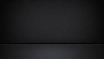 The primary subject of the image is a black background. The setting is a dark room, and the visual style is a black and white photo. The colors and mood are dark and moody, creating a sense of mystery or drama.