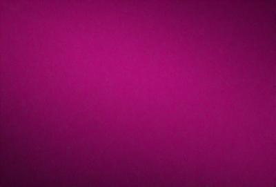 The primary subject of the image is a large, pink wall. The setting is a room with a purple background. The visual style is a close-up of the wall, which gives a sense of depth and texture. The dominant colors are pink and purple, creating a warm and inviting atmosphere.