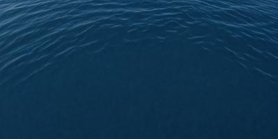 The primary subject of the image is a large body of water, which appears to be a deep blue ocean. The setting is a vast expanse of water, with no visible land or other objects in the background. The visual style of the image is a close-up of the water, showcasing its depth and color. The colors and mood of the image are serene and tranquil, as the deep blue water evokes a sense of calmness and vastness.