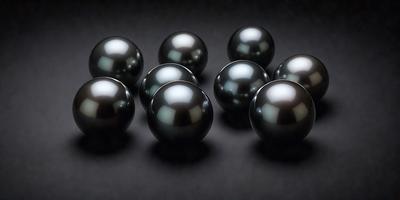The primary subject of the image is a group of black pearls. They are arranged in a circular pattern on a black background. The visual style of the image is a close-up of the pearls, showcasing their unique shapes and textures. The colors and mood of the image are predominantly dark, with the black pearls being the main focus.