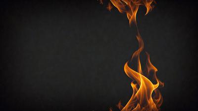 The primary subject of the image is a fire, with flames visible in the foreground. The setting is a black background, which contrasts with the fire's brightness. The visual style is a close-up of the fire, emphasizing its intensity and warmth. The colors and mood of the image are predominantly warm and vibrant, with the fire's flames creating a captivating and dynamic scene.