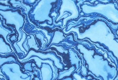 The primary subject of the image is a blue and white swirling pattern, which appears to be a piece of art or a decorative surface. The setting is a blue background, which complements the swirling pattern. The visual style is a combination of artistic and digital elements, creating a unique and eye-catching design. The dominant colors are blue and white, with the blue background providing a calming and soothing atmosphere.