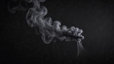 The primary subject of the image is a cloud of smoke, which is the main object, scene, or focus of the image. The setting is a dark background, which creates a dramatic and moody atmosphere. The visual style is a black and white photo, which adds a sense of timelessness and artistic quality to the image. The colors and mood are dominated by the smoke, which appears as a dense and swirling mass, giving the impression of a stormy or dramatic scene.