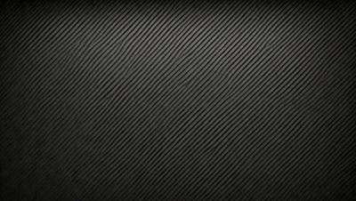 The primary subject of the image is a black background with a patterned texture. The setting is a dark room, and the visual style is a patterned texture. The colors and mood of the image are predominantly dark and moody.