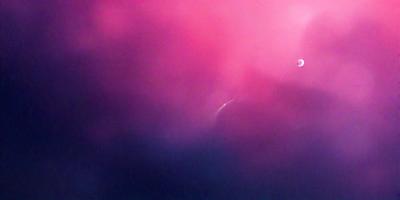 The primary subject of the image is a pink and purple background, which creates a vibrant and colorful atmosphere. The setting is a dark background, which contrasts with the bright colors of the background. The visual style of the image is a combination of photo and digital art, as it appears to be a photo with a digital art-like background. The colors and mood of the image are lively and energetic, with the pink and purple hues evoking a sense of warmth and positivity.