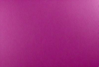 The primary subject of the image is a large, purple wall. The setting is a room with a pink background. The visual style is a close-up of the purple wall, which gives a sense of depth and texture. The dominant colors are purple and pink, creating a warm and inviting atmosphere.