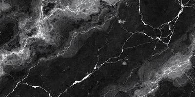 The primary subject of the image is a marble surface with a black background. The setting appears to be a stone wall or a marble countertop. The visual style is a black and white photo, which gives the image a classic and timeless appearance. The dominant colors are black and white, creating a moody and dramatic atmosphere.