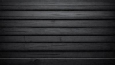 The primary subject of the image is a wooden wall. The setting is a black and white photo, which gives it a classic and timeless appearance. The visual style is a close-up of the wooden wall, showcasing its texture and details. The colors and mood of the image are predominantly black and white, creating a sense of depth and contrast.