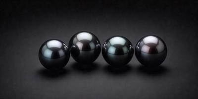 The image features a row of six black and white spheres, arranged in a neat line. The spheres are of varying sizes, and their contrasting colors create a visually appealing composition. The setting appears to be a dark background, which further emphasizes the spheres' contrasting colors. The overall atmosphere of the image is elegant and minimalistic.