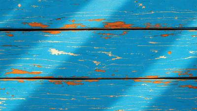 The primary subject of the image is a wooden surface with a blue background. The setting appears to be a wooden wall or a wooden floor. The visual style of the image is a photo, showcasing the wooden surface and the blue background. The colors and mood of the image are predominantly blue, creating a calm and serene atmosphere.