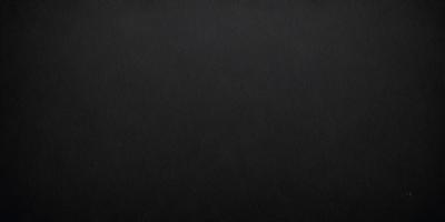 The primary subject of the image is a black background. The setting is a dark room, and the visual style is a black and white photo. The colors and mood of the image are dark and moody, creating a sense of mystery or drama.