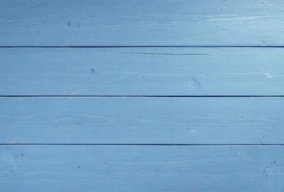The primary subject of the image is a blue wooden wall. The setting is a room with a blue wooden wall, and the visual style is a photo. The dominant colors are blue and white, creating a calm and serene atmosphere.