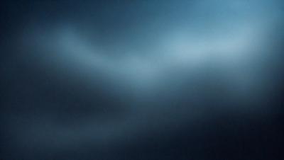 The primary subject of the image is a blue sky with clouds. The setting is a dark blue background, which creates a contrasting effect with the clouds. The visual style is a photo, capturing the beauty of the cloudy sky. The colors and mood of the image are predominantly dark and moody, with the blue sky and clouds creating a sense of depth and tranquility.