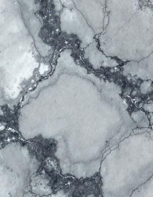The primary subject of the image is a marble surface with a pattern of holes and grooves. The setting is a stone wall, and the visual style is a close-up of the marble surface. The colors and mood of the image are predominantly gray and white, giving it a clean and elegant appearance.