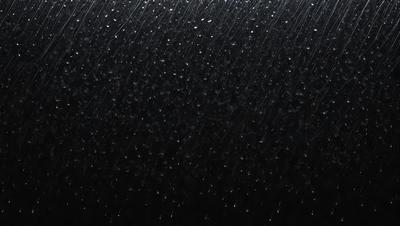 The primary subject of the image is a rainy scene with a black background. The setting is a rainy day, and the visual style is a photo. The dominant colors are black and white, and the overall atmosphere is moody and atmospheric.