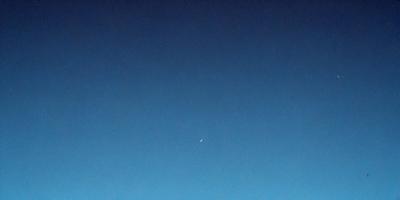 Primary subject: A moon in the sky.

Setting/background: A clear blue sky.

Visual style: A painting or drawing.

Colors and mood: The sky is blue, and the moon is white, creating a serene and peaceful atmosphere.