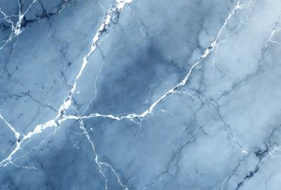 The primary subject of the image is a blue marble wall with white veins. The setting is a room with a blue marble floor. The visual style is a close-up of the marble wall, showcasing its unique texture and design. The colors and mood of the image are predominantly blue and white, creating a serene and elegant atmosphere.