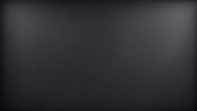 The image is a black and white photo of a blank canvas. The primary subject is the canvas itself, which is the main focus of the image. The setting is a black background, and the visual style is a black and white photo. The colors and mood are predominantly black, creating a stark and dramatic atmosphere.
