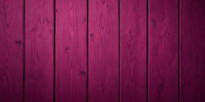 The primary subject of the image is a wooden wall with a purple stain. The setting is a room with a wooden surface, and the visual style is a close-up of the wooden wall. The dominant colors are purple and brown, creating a warm and inviting atmosphere.