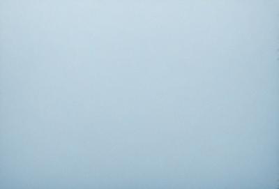 The primary subject of the image is a large, empty, and cloudless blue sky. The setting is a vast, open space with no visible landmarks or objects. The visual style is a natural, untouched, and unaltered representation of the sky. The colors and mood convey a sense of tranquility and vastness, as the blue sky stretches across the entire image.