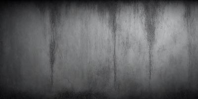 The primary subject of the image is a wall with a rough texture. The setting is a room with a concrete wall, and the visual style is a black and white photo. The dominant colors are black and white, creating a moody atmosphere.