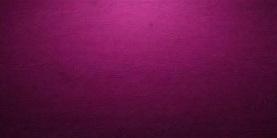 The primary subject of the image is a wall with a purple color. The setting is a room with a wooden surface. The visual style is a close-up of the wall, showcasing the purple color. The dominant colors are purple and pink, creating a calm and soothing atmosphere.