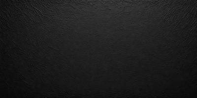 The primary subject of the image is a black leather material, which appears to be a leather-like fabric or a leather-like surface. The setting is a black background, which creates a contrast with the leather material. The visual style is a close-up of the leather material, showcasing its texture and appearance. The colors and mood of the image are predominantly black, giving it a sleek and modern look.