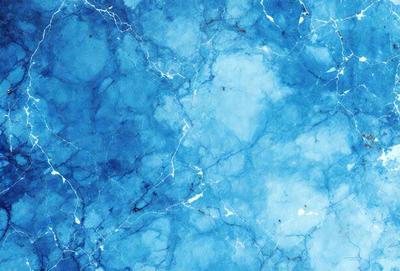 The primary subject of the image is a blue marble wall with a pattern of white veins. The setting is a room with a blue marble floor. The visual style is a close-up of the marble wall, showcasing its unique texture and design. The colors and mood of the image are predominantly blue, creating a serene and calming atmosphere.