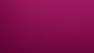 The primary subject of the image is a large, purple sheet of fabric. The setting is a room with a wall that is covered with the purple fabric. The visual style is a close-up of the purple fabric, showcasing its texture and color. The colors and mood of the image are predominantly purple, creating a calm and serene atmosphere.