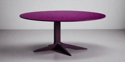 The primary subject of the image is a purple round table. The table is placed on a white surface, which serves as the background. The visual style of the image is a photo, capturing the purple table in its entirety. The colors and mood of the image are predominantly purple, creating a calm and soothing atmosphere.