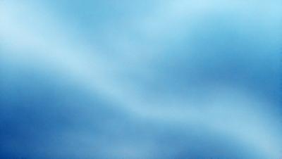 The primary subject of the image is a cloudy blue sky. The setting is a vast expanse of the sky, with no visible land or other objects. The visual style is a natural, outdoor scene. The colors and mood are predominantly blue, with a slightly overcast and moody atmosphere.