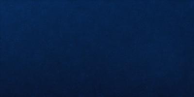 The primary subject of the image is a large, dark blue surface. The setting appears to be a dark, empty room. The visual style is a photo, and the colors and mood are predominantly dark and moody.