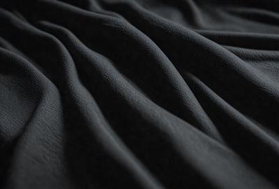 The primary subject of the image is a black fabric, which appears to be a piece of cloth or a curtain. The setting is a dark room, and the visual style is a close-up of the fabric. The colors and mood of the image are predominantly dark and moody, with the black fabric being the main focus.