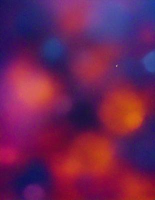 The primary subject of the image is a colorful, swirling pattern of orange and yellow hues. The setting appears to be a night sky, with a star visible in the background. The visual style of the image is a combination of digital art and illustration, creating a vibrant and dynamic atmosphere. The dominant colors and overall mood of the image are warm, lively, and energetic.