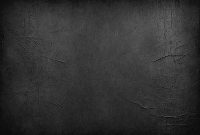 The primary subject of the image is a large, empty, and black canvas. The setting is a dark background, which contrasts with the canvas. The visual style is a black and white photo, giving the image a classic and timeless appearance. The colors and mood are predominantly dark and moody, with the black canvas and background creating a sense of depth and mystery.