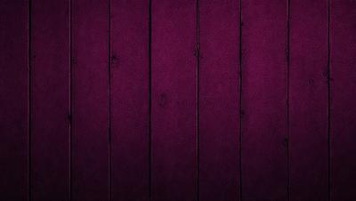 The primary subject of the image is a purple leather wall, which is the main focus of the scene. The setting is a purple wall with a wooden texture, creating a unique and visually striking backdrop. The visual style of the image is a close-up of the purple leather wall, emphasizing its texture and color. The dominant colors in the image are purple and brown, giving the scene a rich and luxurious atmosphere.