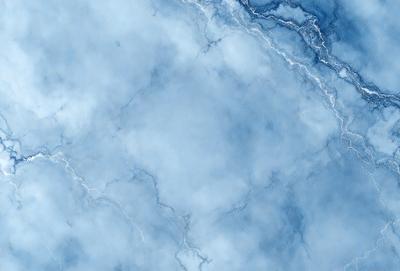 The primary subject of the image is a large, blue, cloudy sky. The setting is a cloudy, blue sky with a few white clouds scattered throughout. The visual style is a photo, capturing the beauty of the cloudy sky. The colors and mood of the image are predominantly blue, creating a serene and calming atmosphere.