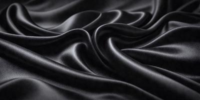 The primary subject of the image is a close-up of a black fabric, possibly a piece of clothing or a curtain. The setting is a dark background, which emphasizes the fabric's texture and pattern. The visual style appears to be a photo, as it captures the details of the fabric. The colors and mood of the image are predominantly dark, with the black fabric being the main focus.
