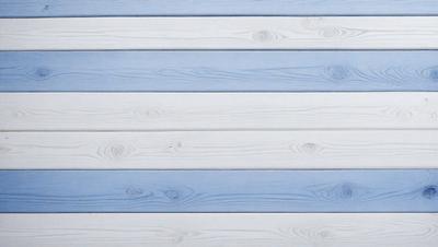 The primary subject of the image is a wooden wall with a blue stripe. The setting is a room with a blue and white color scheme. The visual style is a close-up of the wooden wall, showcasing the grain and texture of the wood. The colors and mood of the image are predominantly blue and white, creating a calm and serene atmosphere.