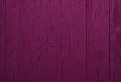 The primary subject of the image is a purple wooden wall. The setting is a room with a purple wooden wall as the main focus. The visual style is a close-up of the purple wooden wall, showcasing its texture and color. The dominant colors are purple and brown, creating a warm and inviting atmosphere.
