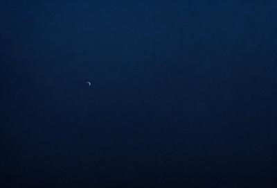 The primary subject of the image is the night sky, which is dark and void of any visible objects. The setting is a vast, open space with no clouds or other celestial bodies. The visual style is a black and white photo, which adds a sense of timelessness and serenity to the scene. The colors and mood are predominantly dark and moody, with the absence of any bright or vibrant elements.