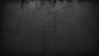 The primary subject of the image is a black and white photo of a wall. The setting is a dark room, and the visual style is a close-up of the wall. The colors and mood of the image are predominantly dark and moody, with the black and white color scheme adding to the atmosphere.