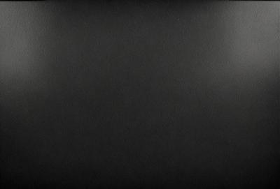 The primary subject of the image is a black background. The setting is a dark room, and the visual style is a black and white photo. The colors and mood are dark and moody, creating a sense of mystery or drama.