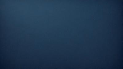 The primary subject of the image is a large, dark blue sky. The setting is a vast, open space with no visible landmarks or objects. The visual style is a simple, unadorned representation of the sky. The colors and mood are predominantly dark and moody, with the blue hue creating a sense of depth and vastness.