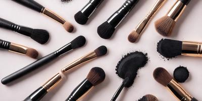 The primary subject of the image is a collection of makeup brushes. There are twelve brushes in total, arranged in various positions on a white surface. The brushes come in different sizes and shapes, showcasing a variety of styles. The setting appears to be a studio or a workspace, where the brushes are displayed for use or for sale. The visual style of the image is a close-up of the brushes, highlighting their details and textures. The colors and mood of the image are predominantly white, which gives it a clean and professional appearance.