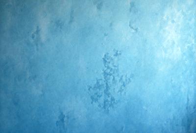 The primary subject of the image is a blue wall with a pattern of white dots. The setting is a room with a blue background. The visual style is a combination of a photo and digital art, creating a unique and interesting pattern on the wall. The dominant colors are blue and white, giving the image a calm and soothing atmosphere.