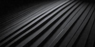 The primary subject of the image is a black and white striped pattern. The setting is a dark background, which contrasts with the light and dark stripes. The visual style is a black and white photo, giving it a classic and timeless appearance. The colors and mood of the image are predominantly dark, with the contrasting light and dark stripes creating a sense of depth and dimension.